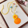 Vue détaillée d'un collier de style plage fait main avec coquillage et fleur jaune - Jaune-Orange