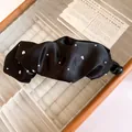 Dettaglio del fermaglio a banana in tessuto nero pieghettato con strass brillanti - Fermaglio a Banana Nero