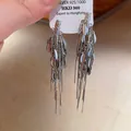 Detailed view of silver 925 long tassel earrings with leaf-shaped metal charms - Olive Leaf Shape Metal Sequin Long Tassel Earring / Style 36# S925 Silver Pin Silver Geometric Triangle Studs