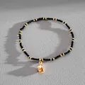 Elegant black and gold beaded bracelet with a vintage-style gold seashell charm pendant - Black Conch