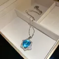 Macro view of a shimmering blue gemstone pendant with a star-shaped halo design. - Blue