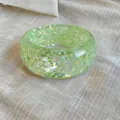 Macro view of a clear green resin bangle featuring shiny iridescent triangle shards. - Green