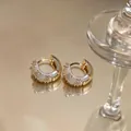 Close-up of gold-plated hoop earrings with zircon stones and white oil-dripping detail - Ear Buckle / Gold-White