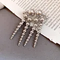 Detailed view of vintage silver cascading ball drop earrings on book page background - Silver