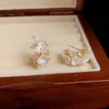 Detailopname van elegante Franse witte bloemenoorbellen in een houten juwelendoosje. - Bloemstijl (HE32384-1) / Zilveren naald / Goud/Wit