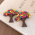 Gros plan sur des boucles d'oreilles en forme d'arbre avec des perles en bois colorées - Marron-Multicolore