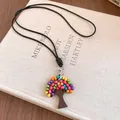 Gros plan d'un collier pendentif arbre bohème avec perles de bois colorées et cordon noir - Noir-Multicolore