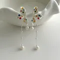 Detailed macro view of colorful polka dot flower earrings featuring long pearl tassels - Colorful Polka Dot Floral Tassel / Silver