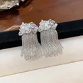 Detail of silver tassel earrings featuring pearls and unique wrinkled metal texture. - Silver Needle / Silver