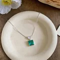 Détail d'un pendentif en pierre verte taille émeraude avec zircon en forme de cœur chic - Collier / Argent-Vert
