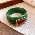Close-up detail of a stylish green acrylic bangle with a square amber-colored resin stone - Green And Coffee