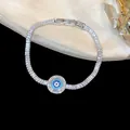 Gros plan d'un bracelet tennis argenté avec zircons brillants et breloque œil bleu maléfique. - Style Rond Mauvais Œil (HB5294) / Argent