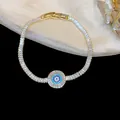 Detailed close-up of an 18k gold plated zircon bracelet featuring a blue evil eye motif - Round Evil Eye Style (HB5293) / Gold