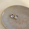 Dettaglio di orecchini minimalisti in argento con scintillanti zirconi a forma di cuore. - Argento (Placcato Oro Vero)