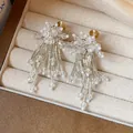 Detailed close-up of elegant crystal glass flower tassel clip-on earrings in box - Flower Tassel Ear Clip / White