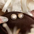 Detailed close-up of elegant French oval stud earrings with gold bezel and cat eye stone - Silver Earring Post Style / Gold-Round