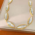 Detailed close-up of vintage marquise-cut crystal necklace with gold beaded border design - Gold-White