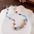Macro detail of a colorful resin stone beaded necklace with flower charms on a plate. - Necklace (HN12095) / Colorful