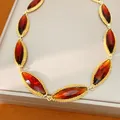 Macro detail of vintage marquise cut red gemstones set in elegant gold-plated settings - Gold Brown