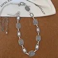 Close-up of vintage silver ethnic waist chain with embossed metal links on cork background. - Style 16