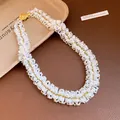 Detailed view of handmade multi-strand pearl beadwork and elegant golden clasp - Necklace / Gold-White