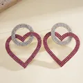 Primer plano detallado de lujosos pendientes de corazón rosa y círculo de diamantes - Estilo de Corazón Geométrico Exagerado / Rosa