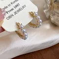 Detailed view of 14k gold-plated hoop earrings with small elegant pearls. - Pearl Hoop Earrings / Gold