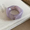 Close-up detail of a chunky purple resin open bangle with a unique geometric design. - Purple