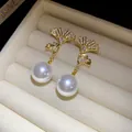 Macro view of gold-plated ginkgo leaf earrings with zircon and drop pearls - Gold Ginkgo Leaf White Pearl / Silver Earring Post Real Gold Plated