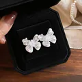 Detailed view of the pearlescent butterfly stud earrings with clear zircon accents - Mother-of-Pearl Texture Pearl Butterfly Studs / Silver