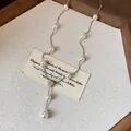 Gros plan d'un collier de perles élégant de style français avec fleur en zircone - Argent-Blanc