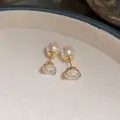 Close-up of elegant gold earrings featuring two-way wear with white pearls and zircons - Front-Back Two-Way Wear / Gold