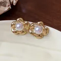 Close-up of vintage gold-plated flower stud earrings with elegant central pearl - Flower Style (HE31772) / Gold