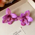 Detailansicht handgefertigter violetter Orchideenohrringe mit glänzenden Harzblüten - Stil mit Silber-Ohrstecker / Lila