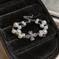 Close-up of elegant double-strand pearl bracelet with zircon clover heart pendant - Pearl Bracelet