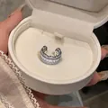 Macro view of a sparkling cubic zirconia C-shaped ear cuff inside a white jewelry gift box - Ear Clip - Single Piece / Silver
