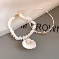 Detailed view of white shell and starfish beaded necklaces for beach vacation outfits. - White