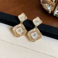 Detailansicht der 18K vergoldeten Rauten-Ohrringe mit weißem Emaille- und Zirkon-Inlay - 925 Silber Stift Stil / Gold mit Weiß