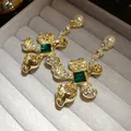 Vintage style silver needle gold floral earrings with emerald green crystals and pearls. - Gold