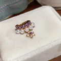 Macro view of elegant gold ear cuff featuring purple stones and star charm with white pearls - Ear Clip (Purple-White)