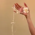 Primo piano di un elegante choker da sposa floreale bianco con nastro e perle - Collana / Bianco