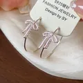 Detail of pink bow hoop earrings with zirconia and enamel finish on silver pins. - Pink