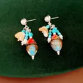 Macro view of vintage ethnic tassel earrings with colorful glass beads and elegant pearls. - Earring Post Tassel Style / Silver-Blue-Coffee