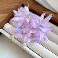 Close-up detail of pink fabric flower earrings with pearls and delicate gold tassels - Pink