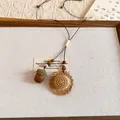 Close-up of the handcrafted acorn and miniature straw hat pendants on a brown cord necklace - Rattan Flat Hat Style (4#)