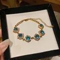Dettaglio del bracciale placcato oro 18K con zirconi blu in una scatola regalo - Stile Rotondo / Oro-Blu