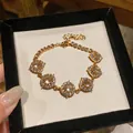 Primo piano di un elegante bracciale placcato oro 18 carati con pietre di zircone lucide - Stile Rotondo / Oro-Trasparente