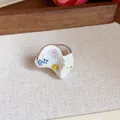 Vue détaillée d'une bague en émail blanc ornée de motifs floraux colorés peints à la main - Style Fleur Courbée Irrégulière (HR3112)