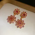 Macro detail of retro palace style floral earrings featuring pink and red rhinestones - Earrings / Pink