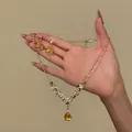 Detailed macro view of an elegant yellow waterdrop zircon necklace and earrings set - Water Drop Necklace Earring Set (HN11489) / Gold-Yellow